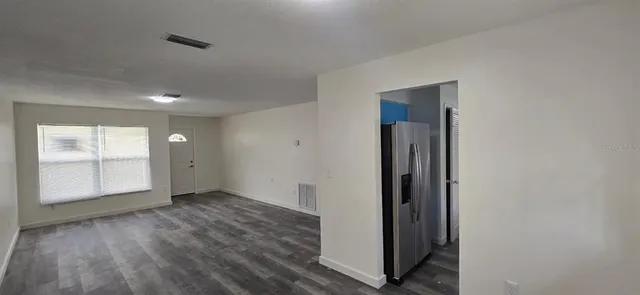 an empty room with wooden floor and a window