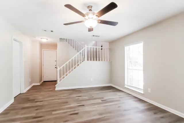 an entryway in a hall with a window and a ceiling fan