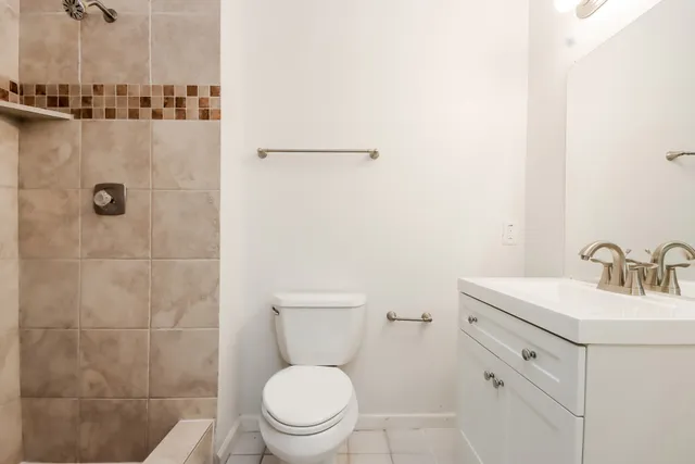 a bathroom with a toilet sink vanity and mirror