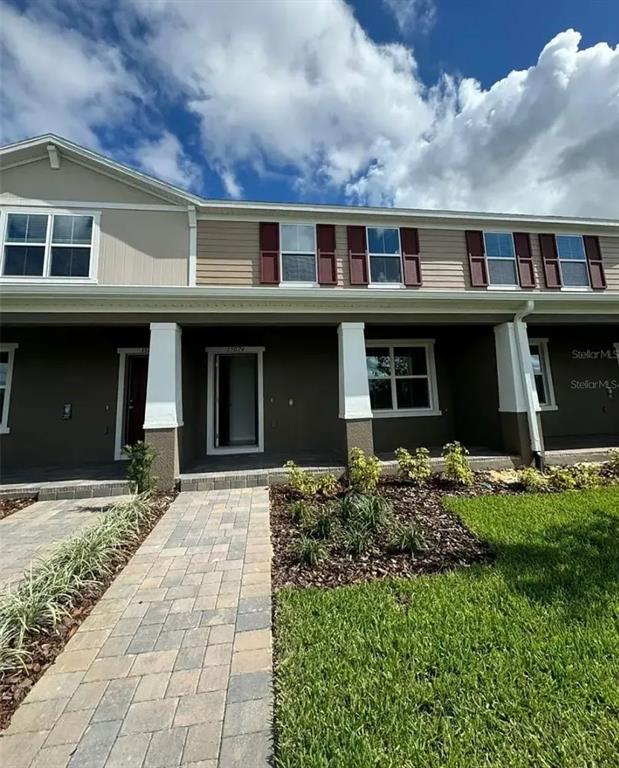 front view of a brick house with a yard