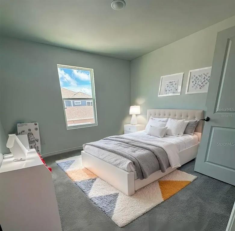 15074 Windflower Alley Winter Garden, FL 34787 - Photo 8 of 18 a bedroom with bed and window