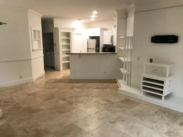 a view of kitchen with stainless steel appliances cabinets and a refrigerator