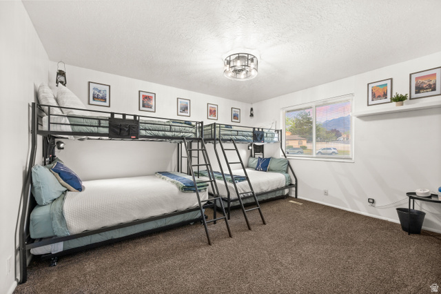 9750 Indian Ridge Drive Sandy, UT 84092 - Photo 23 of 40 Bedroom featuring dark carpet and a textured ceiling