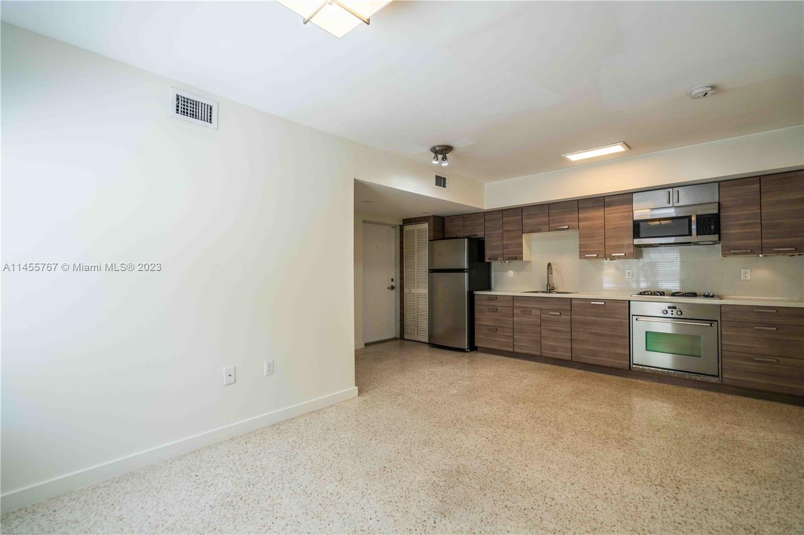 666 Northeast 80th Street, Unit 5 Miami, FL 33138 - Photo 5 of 19 a kitchen with stainless steel appliances a refrigerator and cabinets