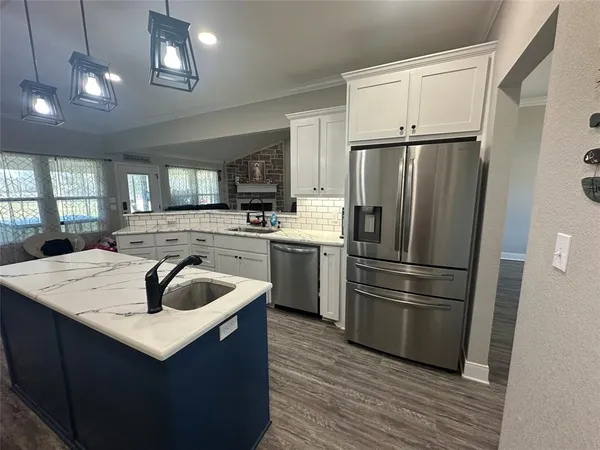a kitchen with kitchen island a sink a counter space and stainless steel appliances
