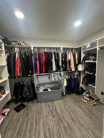 a view of walk in closet with clothes and shoes