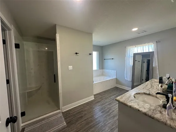 a bathroom with a granite countertop sink a mirror and shower