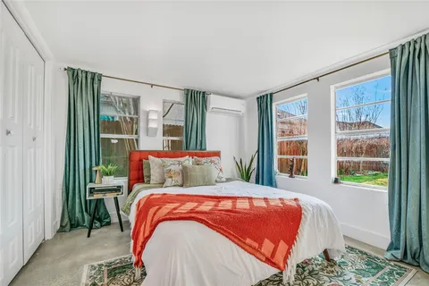 a bed sitting in a bedroom next to a window