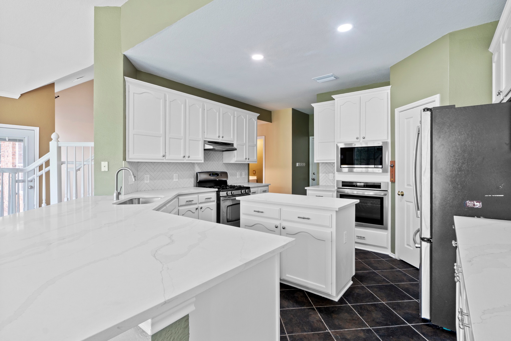 8605 Axis Drive Austin, TX 78749 - Photo 13 of 38 White cabinetry and stone countertops elevate this kitchen, complete with modern appliances and ample preparation space.