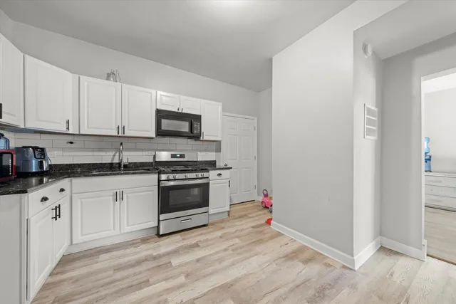 a kitchen with granite countertop white cabinets and white appliances