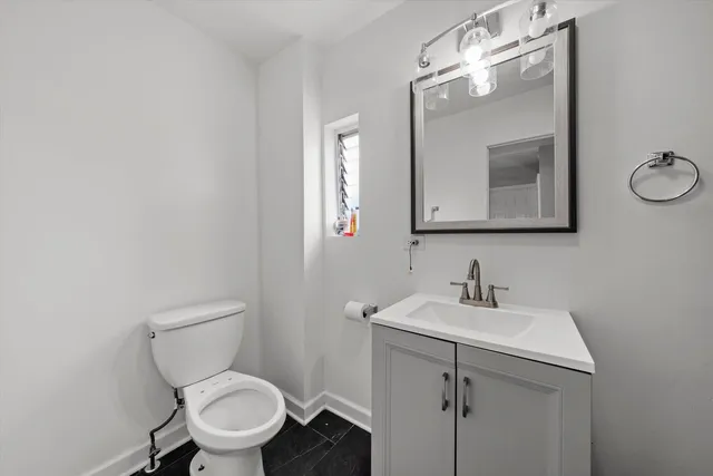 a bathroom with a toilet sink and mirror
