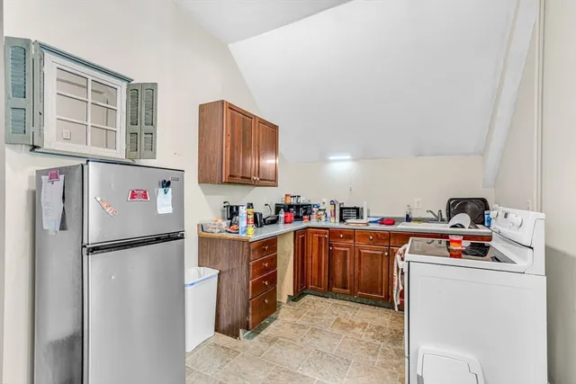 a kitchen with refrigerator and cabinets