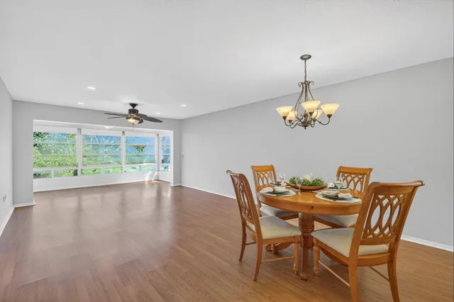 a view of a dining room with furniture a chandelier and wooden floor