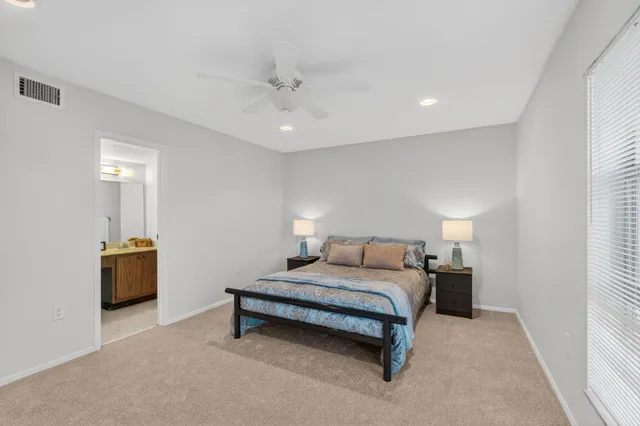 a spacious bedroom with a bed and a chandelier