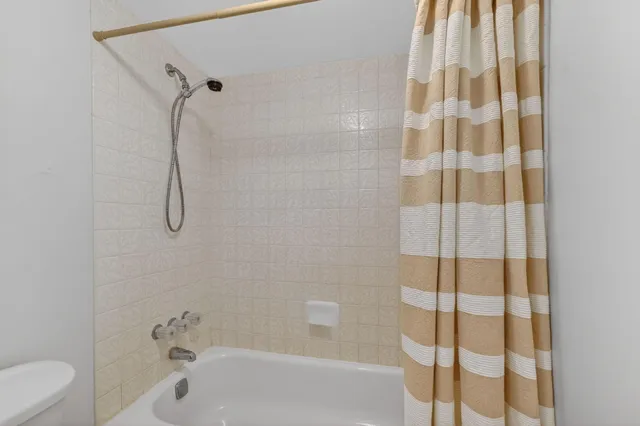 a bathroom with a shower curtain and a bathtub