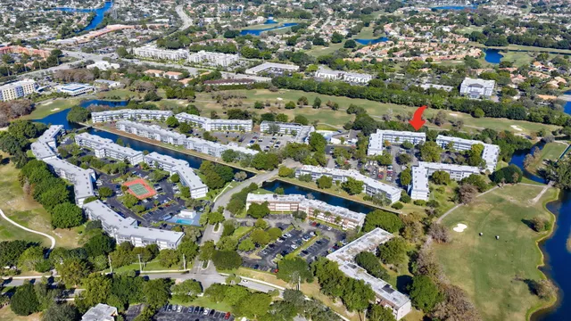 an aerial view of residential houses with outdoor space and trees
