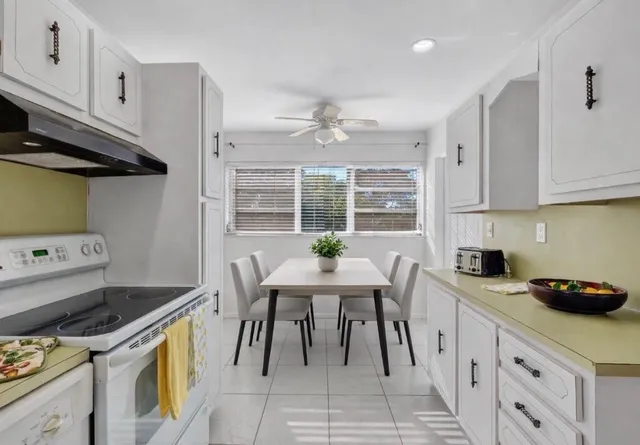 a kitchen with stainless steel appliances granite countertop a stove a sink a refrigerator and a cabinets