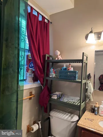 a bathroom with a toilet a sink and curtain