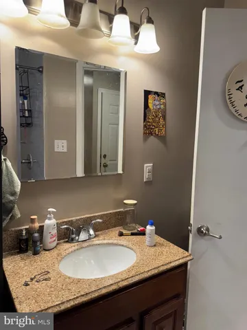 a bathroom with a granite countertop sink and a mirror