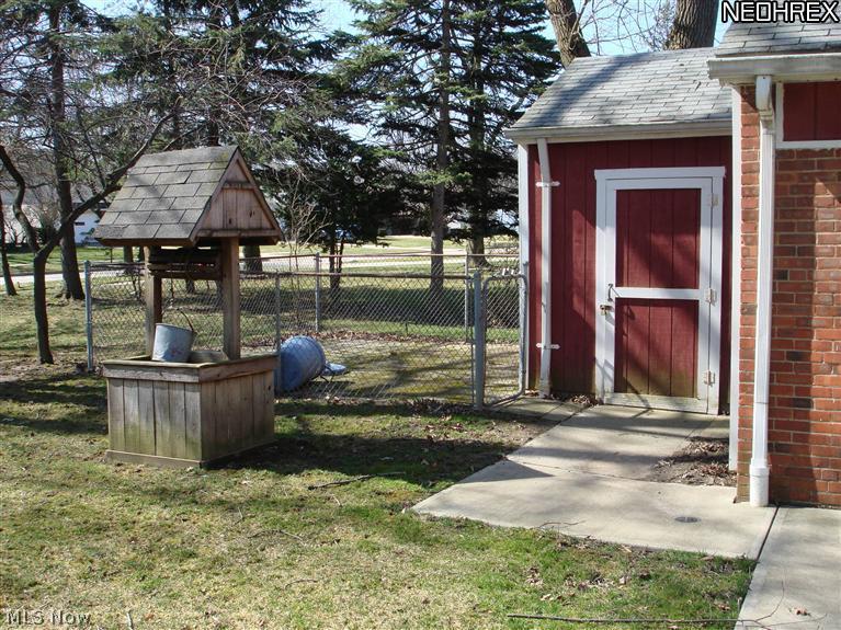 1784 Sunview Road Cleveland, OH 44124 - Photo 17 of 20 View of fenced in area for animals or outside storage, decorative well, and separate entry to bonus workshop (also accessible from garage)