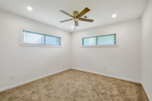 an empty room with closet and fan