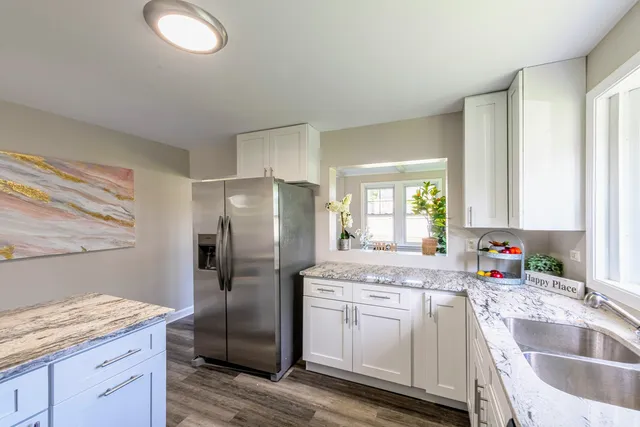 a kitchen with granite countertop a sink stainless steel appliances and cabinets