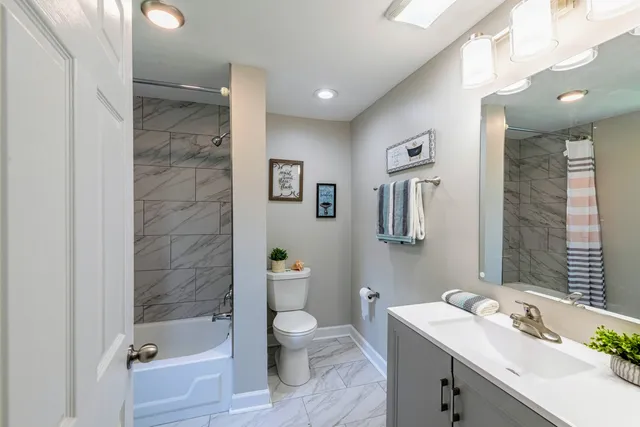 a bathroom with a sink a toilet and shower