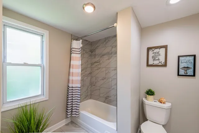 a bathroom with a toilet and a shower