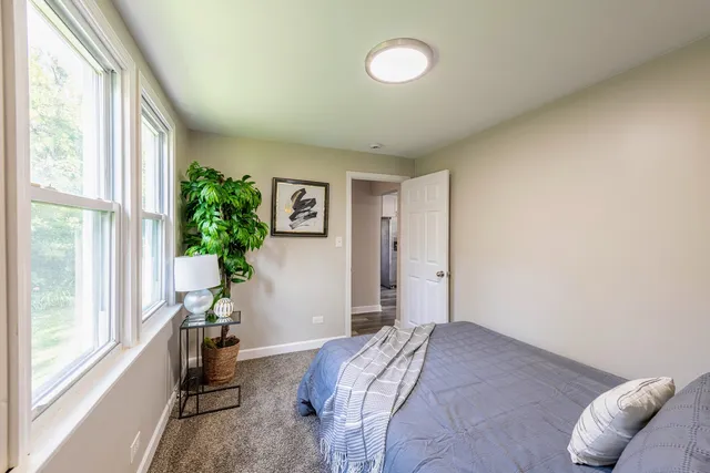 a bedroom with a bed and a potted plant