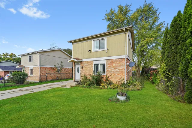 a view of a house with a yard and sitting area