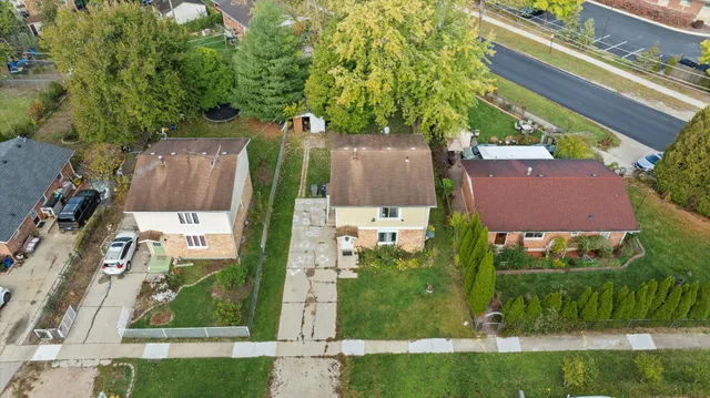 an aerial view of residential houses with outdoor space and trees