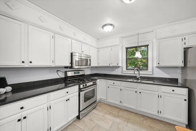 a kitchen with granite countertop white cabinets white stainless steel appliances and sink