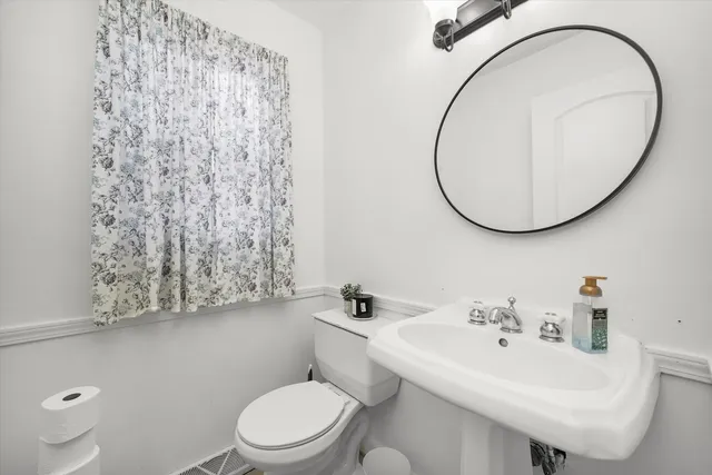 a bathroom with a sink a toilet and a mirror