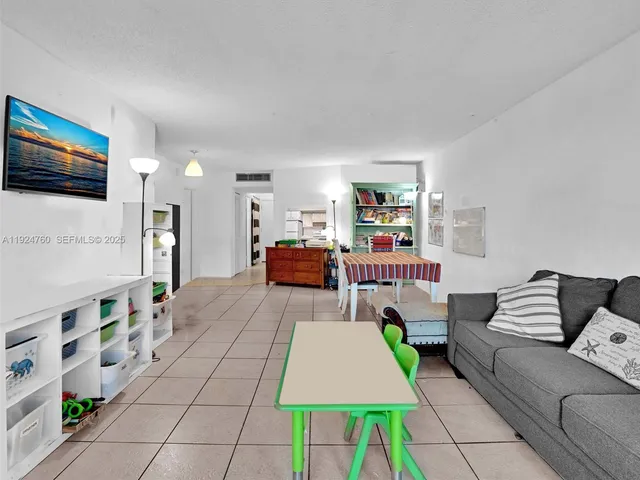 a bedroom with a large bed and a flat tv screen on dresser