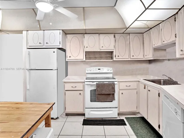 a kitchen with white cabinets and white appliances