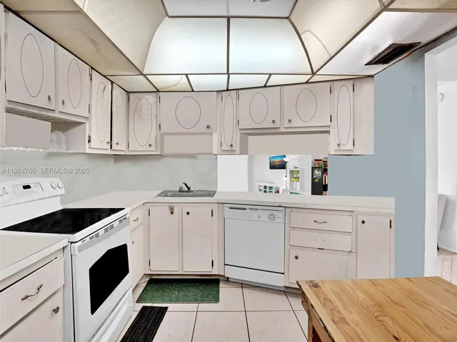a kitchen with white cabinets and white appliances