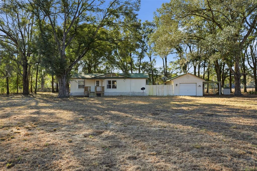 a view of a house with a yard and tree s