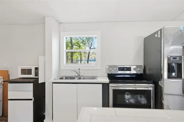 a kitchen with stainless steel appliances a stove microwave and refrigerator