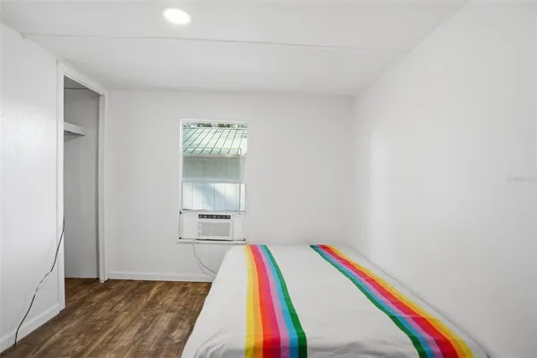 a room with a bed and wooden floor