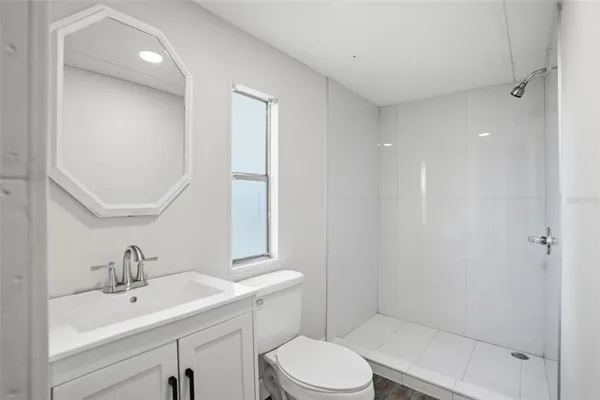 a bathroom with a sink a toilet and shower