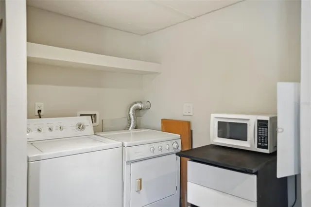 a view of washer and dryer with kitchen in the background
