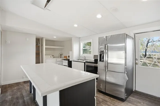a kitchen with refrigerator and chairs