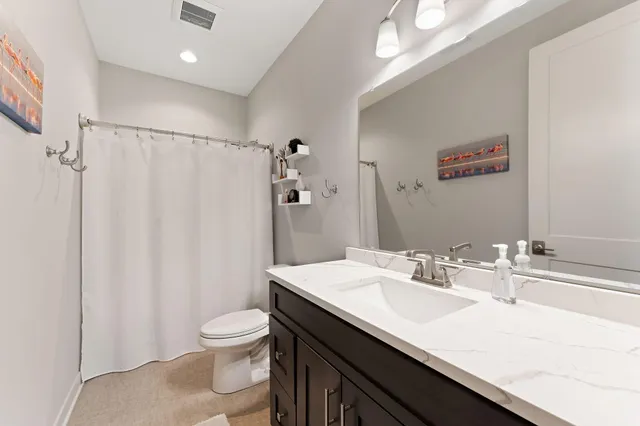 a bathroom with a sink a toilet a mirror and shower