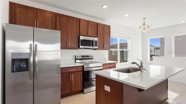 a kitchen with stainless steel appliances a sink a counter top space cabinets and a window