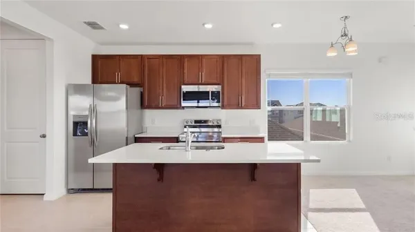 a kitchen with stainless steel appliances granite countertop a sink refrigerator and cabinets
