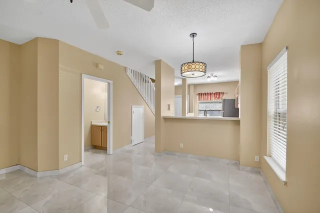 a view of a hallway with windows and chandelier