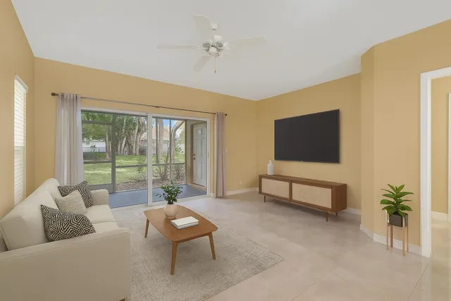 a living room with furniture a flat screen tv and a large window