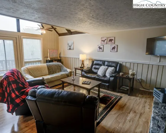 a living room with furniture and a flat screen tv with wooden floor