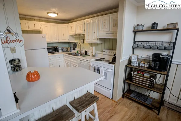 a kitchen with a refrigerator a stove and white cabinets