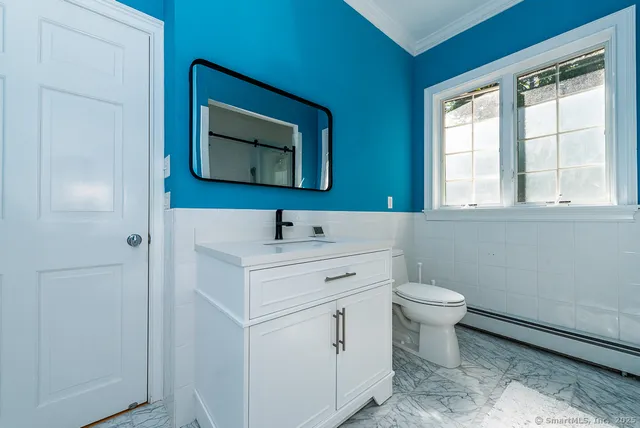 a bathroom with a toilet sink and mirror